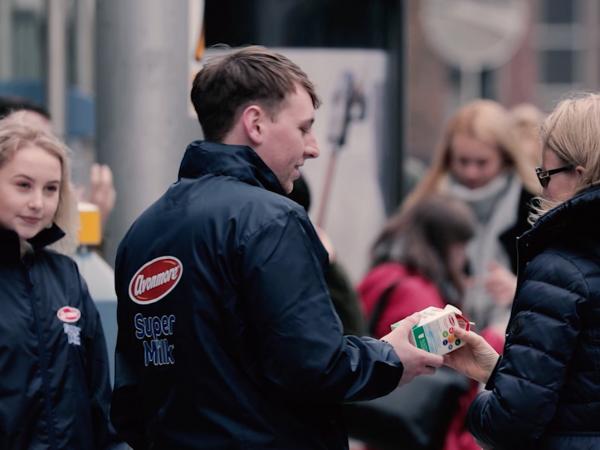 Boy and girl handing avonmore milk to a women