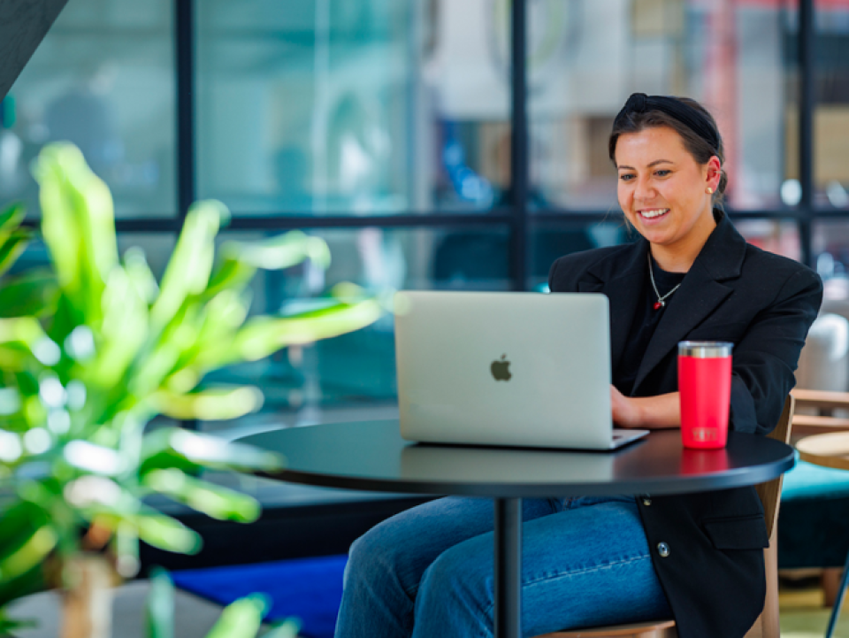 Woman sitting at a deak working on a laptop